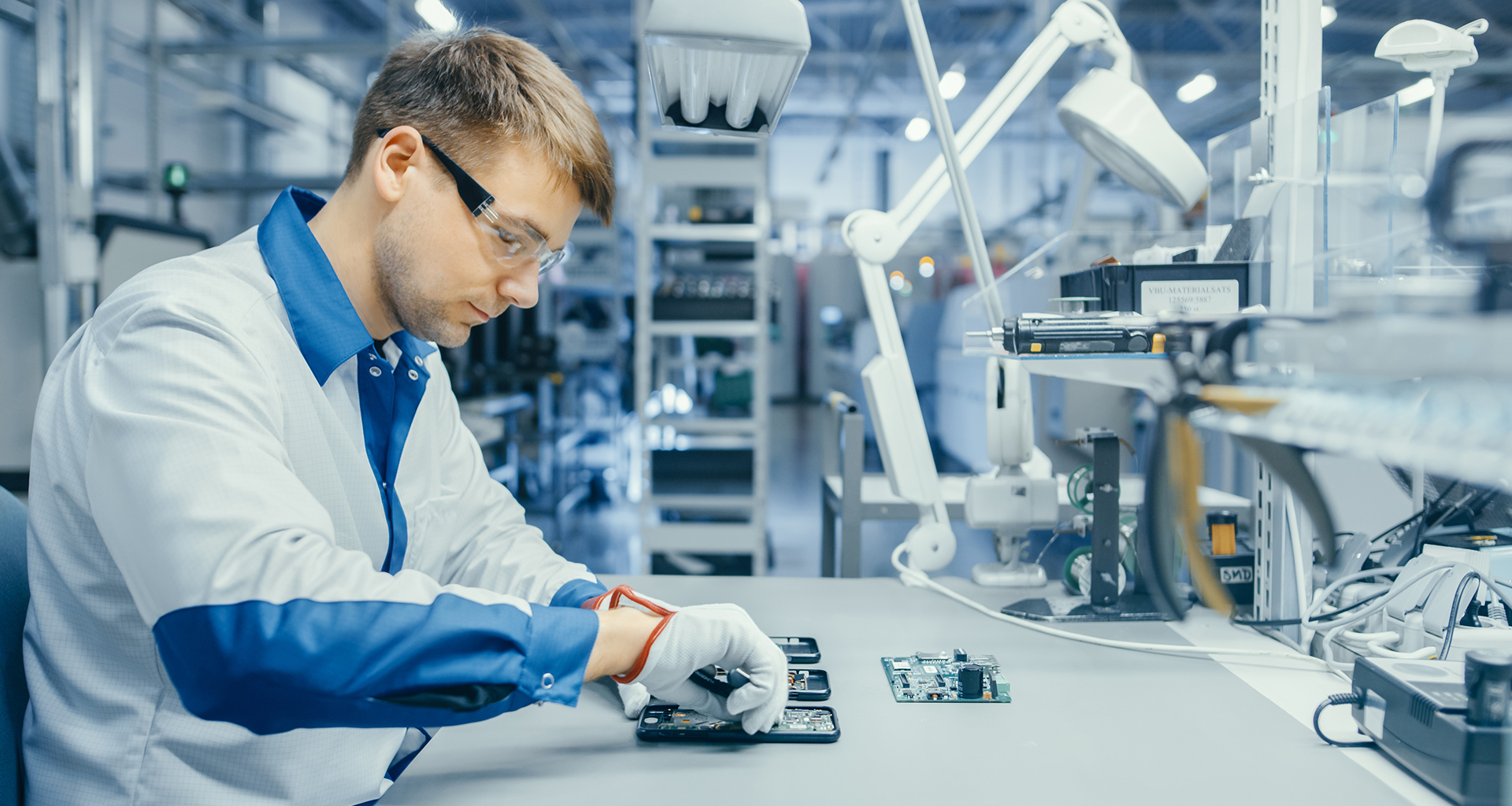 A technician with electrical components in a lab